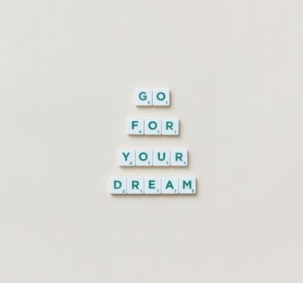 Inspirational text 'Go For Your Dream' made from Scrabble tiles on a plain background.
